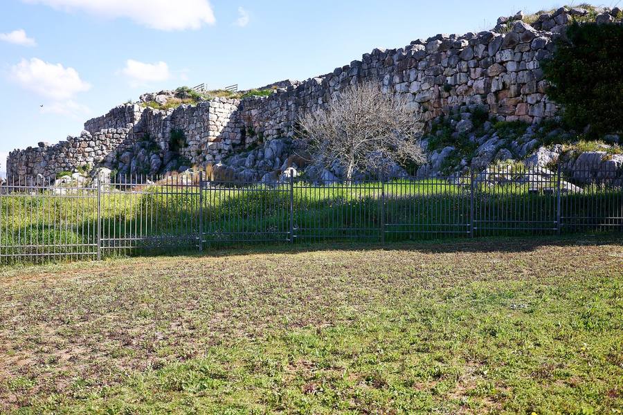 Tramo de muralla de enormes bloques de piedra encajados sin argamasa, sobre la roca